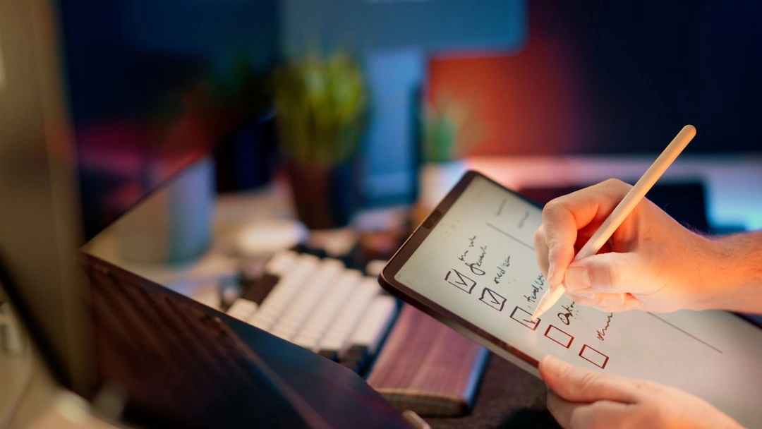 A user with a tablet and stylus checking off items in a checklist