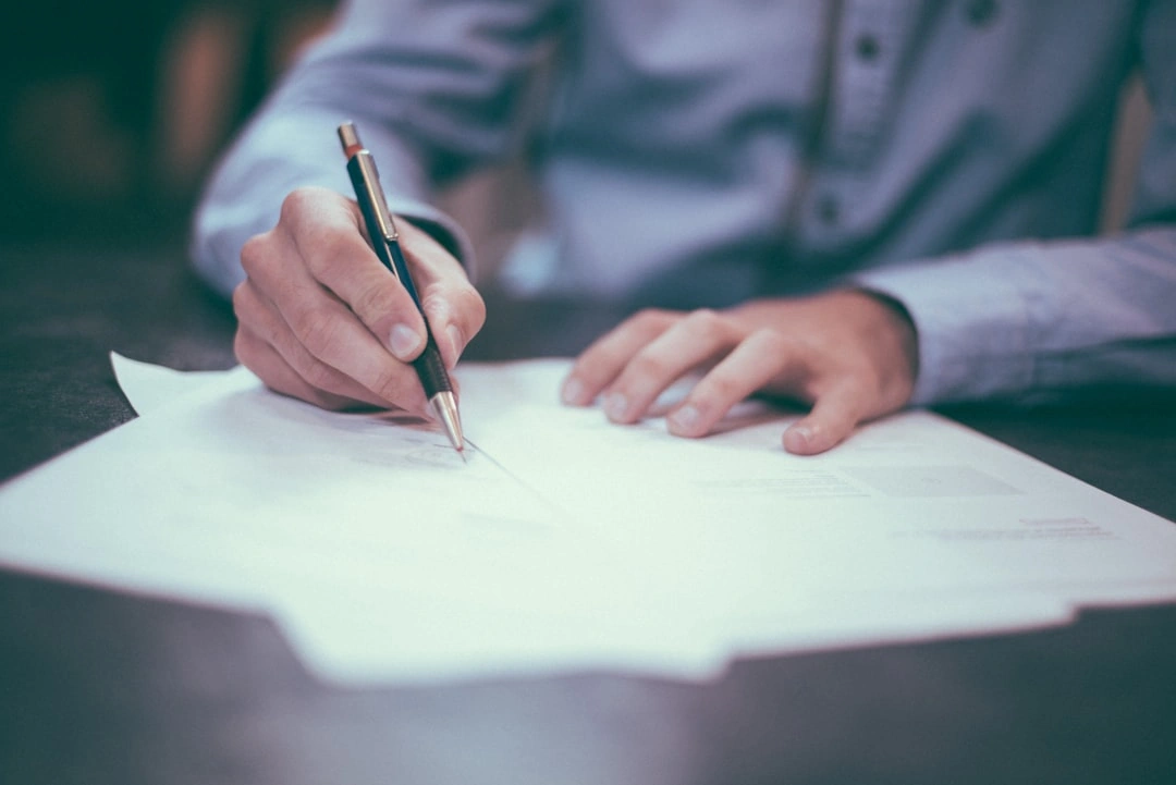 Man using a pen to write on legal paper