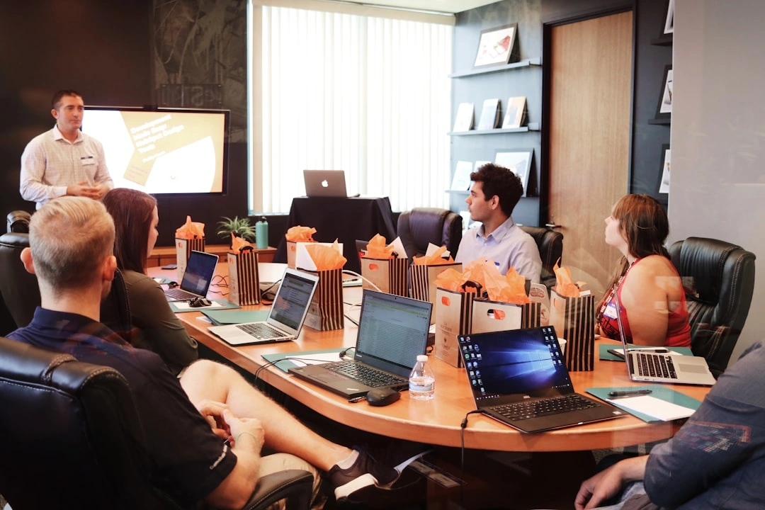 A group of professionals at a conference table with laptops